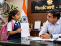 मऊ में खराब सड़क की शिकायत लेकर DM कार्यालय पहुंची कक्षा 1 की छात्रा का प्रतीकात्मक दृश्य।